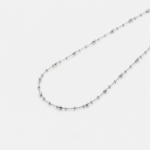 Detailed close-up view of the fine textured links and subtle reflective details on the strand of the chain necklace crafted with premium rhodium plating