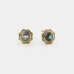 A pair of two-tone 18K gold plated sterling silver stud earrings featuring round iridescent natural abalone shell centerpieces framed by sculptural silver starburst rays on a clean white background.