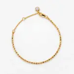 ONDA LENTA 18K gold plated sterling silver beaded bracelet with a clear stone charm and adjustable extension chain.