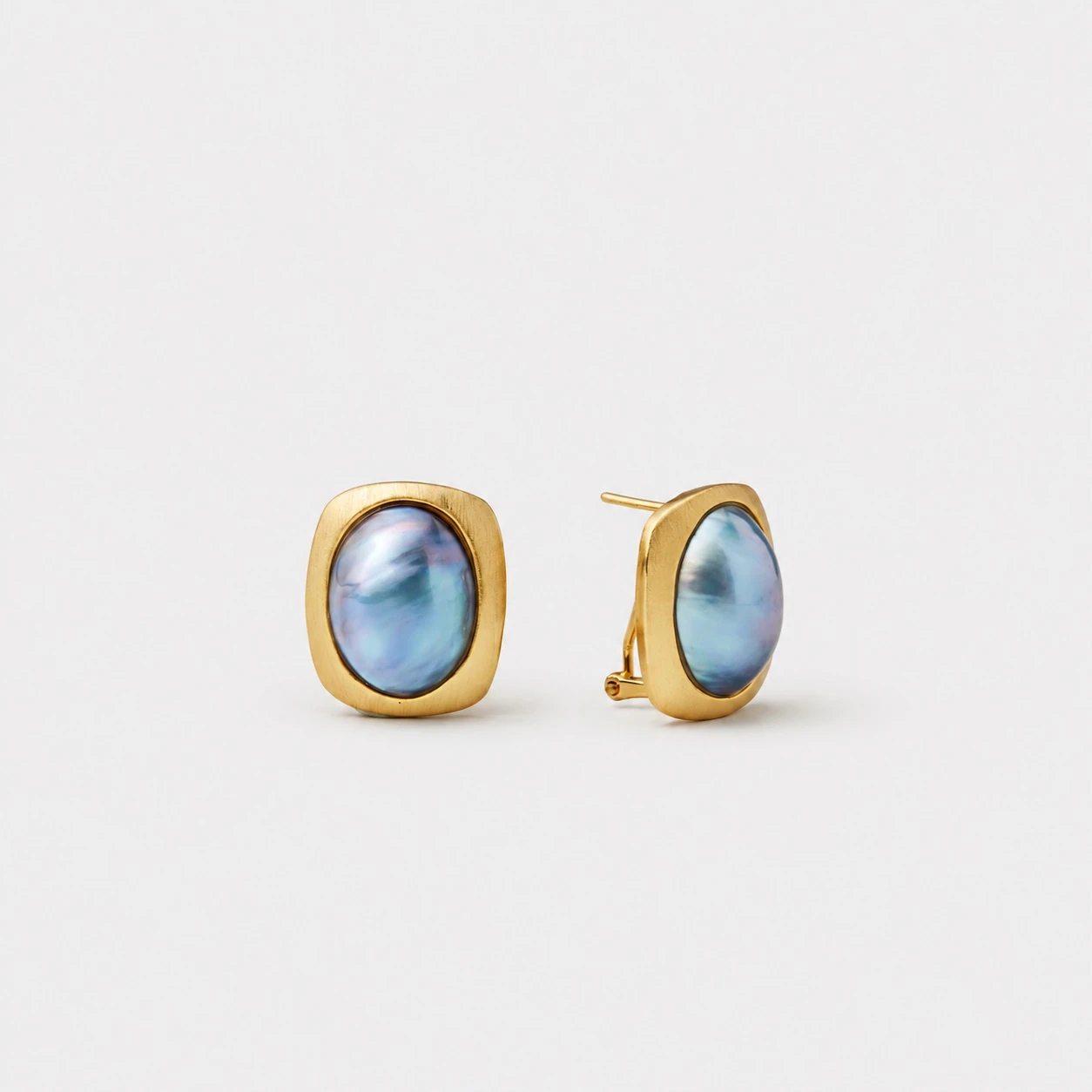 18k-gold-plated-sterling-silver-mabe-pearl-stud-earrings-rounded-square-frame-iridescent-blue-green 18K gold plated sterling silver mabe pearl stud earrings with a rounded square frame and iridescent blue-green, ocean blue, and subtle violet tones under varied light