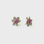 18K gold plated sterling silver ruby stud earrings featuring a floral shape with green pavé accents.