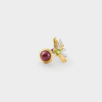 Profile detail view showing the textured bark-like silver band of the gemstone ring with a detailed gold plated bezel holding the ruby cabochon.