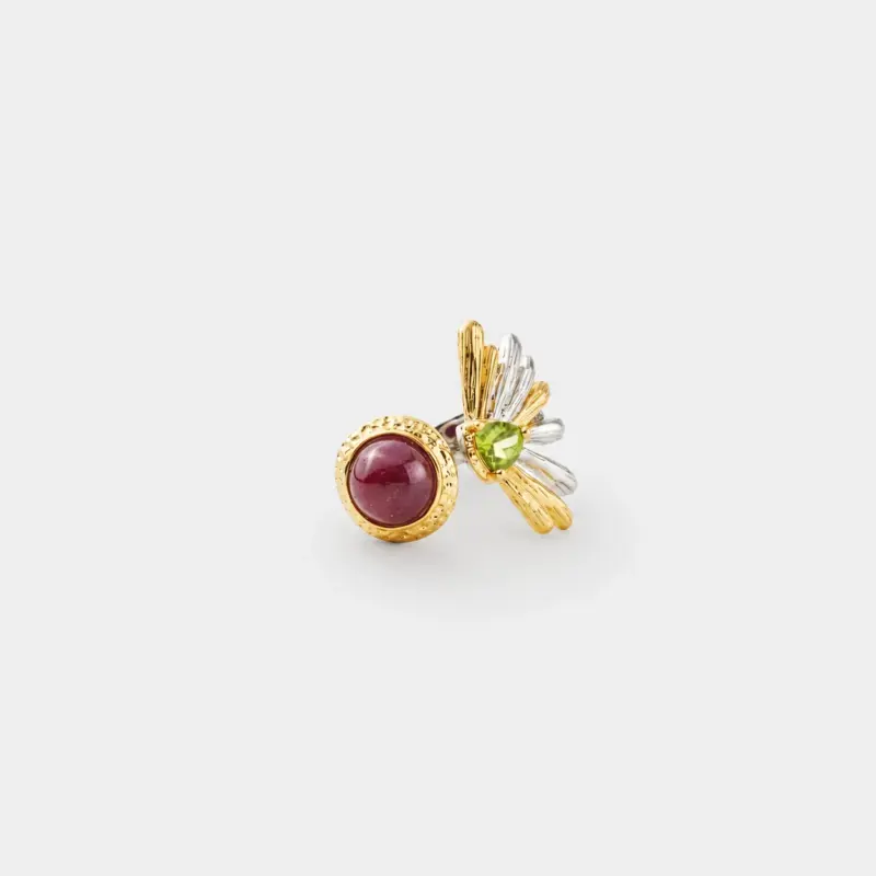 18K gold plated two-tone sterling silver ruby ring featuring a rounded cabochon center and an artistic flower-like peridot side structure.