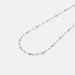 Detailed close-up view of the fine textured links and subtle reflective details on the strand of the chain necklace crafted with premium rhodium plating