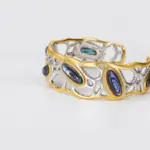 ONDA LENTA two-tone openwork cuff bracelet featuring oval abalone shell inlays with iridescent blue, green and purple tones.