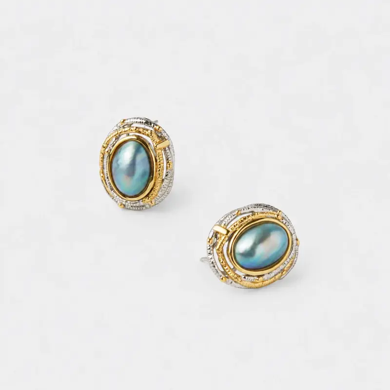 Angled close-up view showing the textured two-tone accents and secure post backs of the mabe pearl stud earrings with premium gold and silver plating