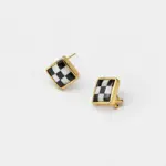 Angled detail view showing the checkerboard inlay of black agate and mother of pearl square stud earrings with an 18K gold plated frame.