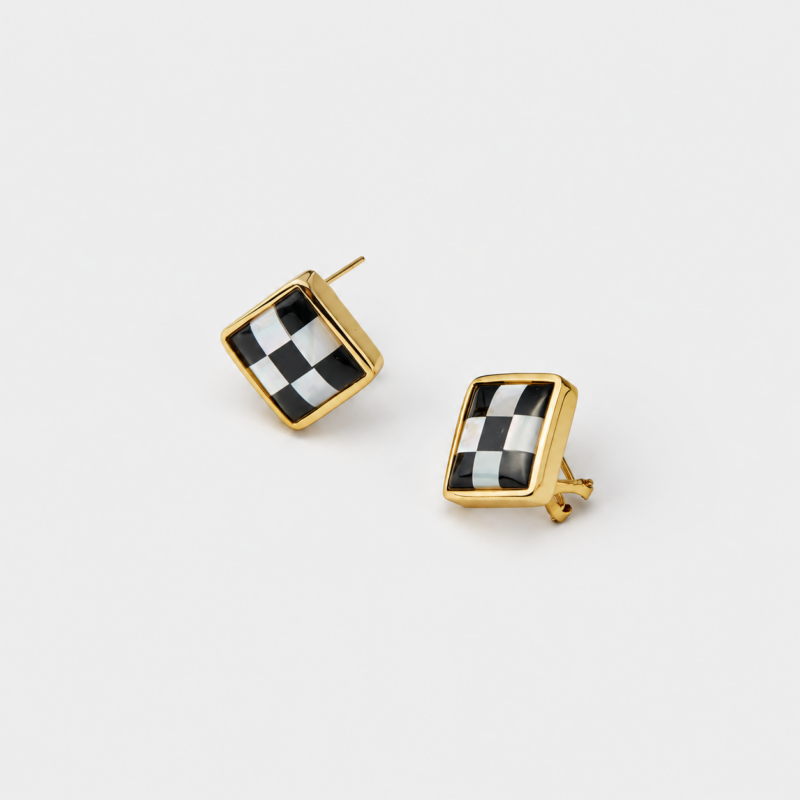 Angled detail view showing the checkerboard inlay of black agate and mother of pearl square stud earrings with an 18K gold plated frame.