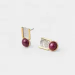 Angled detail view showing the rippled textured silver surface of the geometric stud earrings with a gold plated frame backing.