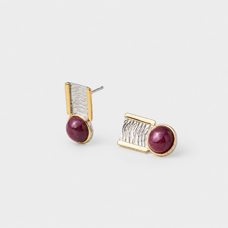 Angled detail view showing the rippled textured silver surface of the geometric stud earrings with a gold plated frame backing.