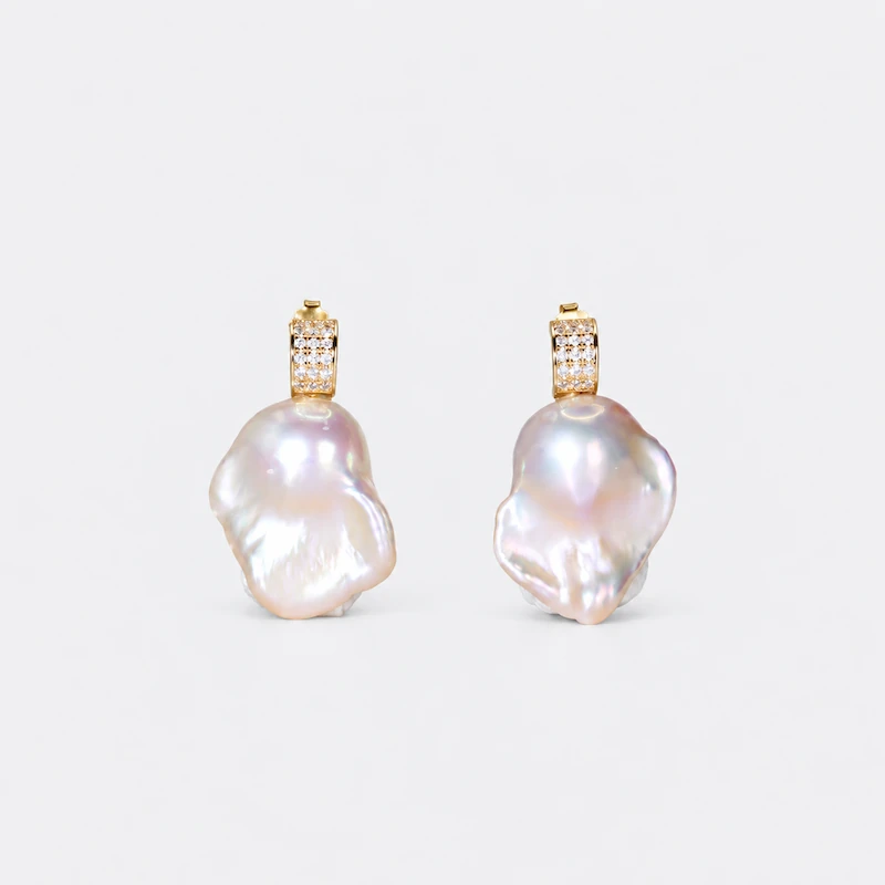 ONDA LENTA baroque pearl drop earrings featuring large irregular white pearls with lustrous iridescence and gold sparkling stone settings.