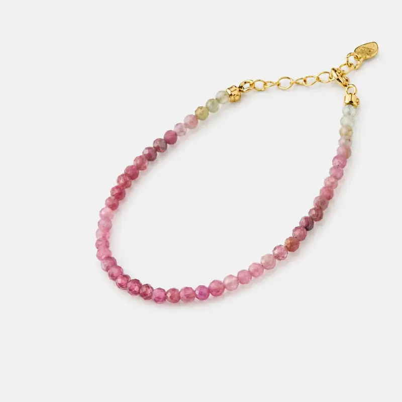 Close-up detailed view highlighting the natural variation of pink and green faceted tourmaline beads on this strand bracelet finished with an 18K gold plated sterling silver adjustable chain