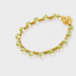 Close-up detailed view highlighting the smooth light green peridot beads and textured gold-tone spacers on this beaded strand bracelet crafted with 18K gold plated sterling silver
