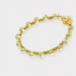 Close-up detailed view highlighting the smooth light green peridot beads and textured gold-tone spacers on this beaded strand bracelet crafted with 18K gold plated sterling silver