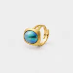 Close-up detailed view focusing on the iridescent turquoise and violet hues of the bezel-set blue mabe pearl statement cocktail ring crafted in premium 18K gold plated sterling silver