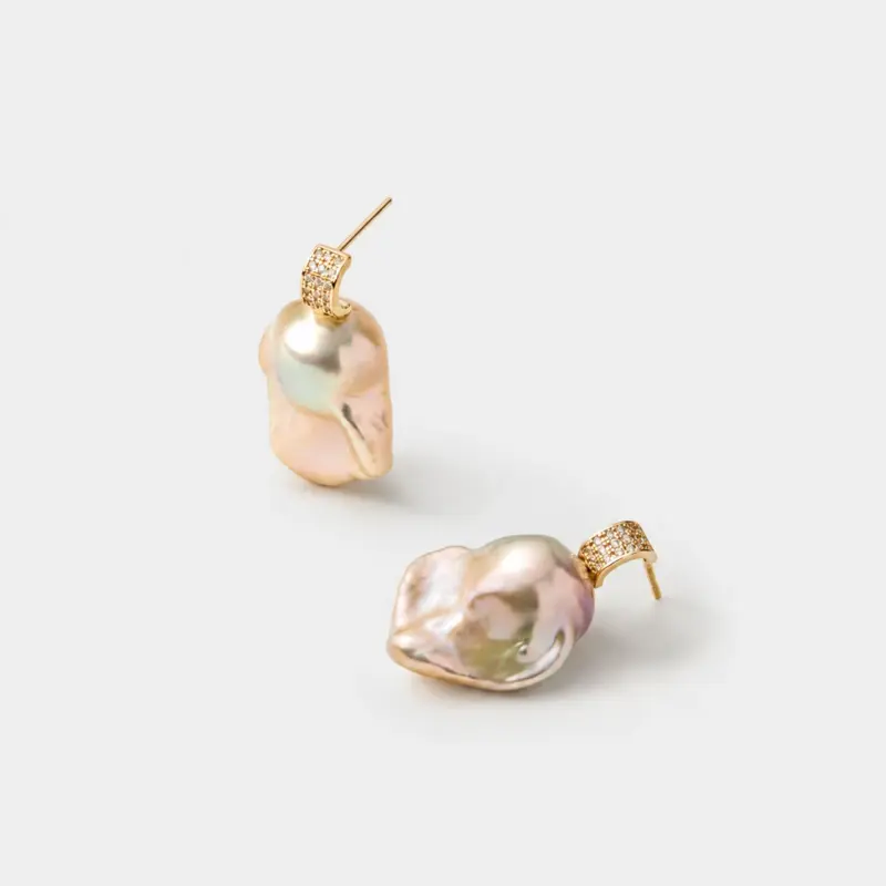 Detailed close-up view of the zircon-pave textured stud and natural pearlescent luster on these irregular baroque pearl drop earrings with 18K gold plated sterling silver craftsmanship