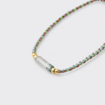 Close-up detailed view of the textured woven braided cord and smooth gradient green chalcedony beads on the focal strand bracelet with 18K gold plated sterling silver accents