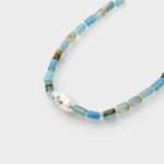 Close-up perspective view showing a baroque pearl with turquoise inlay and cylindrical blue opal beads on a 925 sterling silver necklace.