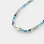 Close-up perspective view showing a baroque pearl with turquoise inlay and cylindrical blue opal beads on a 925 sterling silver necklace.