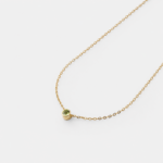 Detailed close-up view showcasing the round bezel-set green peridot stone on a fine 18K gold plated sterling silver cable chain