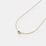 Detailed close-up view showcasing the round bezel-set green peridot stone on a fine 18K gold plated sterling silver cable chain