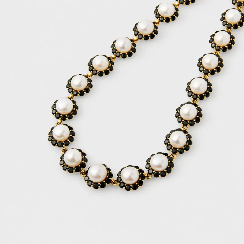 Close-up view showing the detailed black spinel gemstone halos framing white pearl centers connected by gold plated silver links.