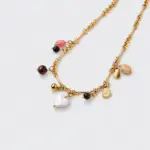 Close-up perspective view showing a heart-shaped shell pendant and dangling gemstone charms on an 18K gold-plated necklace.