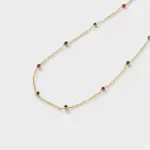 Close-up view showing red, green, and deep blue corundum accents spaced along a fine gold chain necklace in 18K gold plated silver.