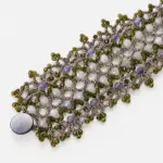 ONDA LENTA wide woven gemstone bracelet with faceted green, white and lavender stones arranged in an intricate openwork design.