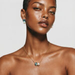 Model wearing Abalone Pearl Stud Earrings on her earlobes paired elegantly with a matching pendant chain necklace for a modern workwear or travel look.