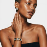 Model wearing Black Agate MOP checkerboard square stud earrings on her earlobes paired with a matching statement bracelet.