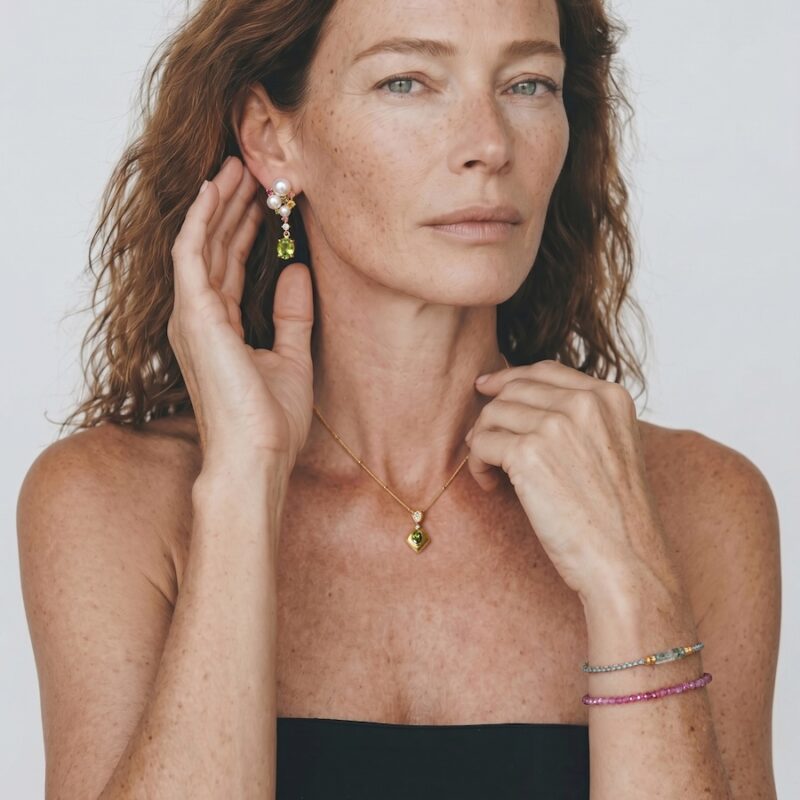 Model wearing Blooming Banquet peridot pearl drop earrings with joyful gemstone clusters on her ears for graceful everyday outfit styling