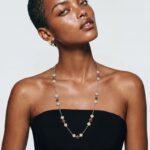 Model wearing Blossom Ruby Necklace draped elegantly over a black strapless top for a sophisticated everyday look.