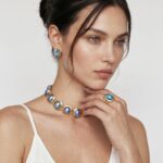 Model wearing Blue Mabe Pearl Ring with a bold gold frame and iridescent ocean-blue luster on her finger for an elegant, polished office look