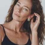 Model wearing Blue Mabe Pearl Stud Earrings with an organic ocean-like glow on her earlobe for a polished everyday look