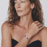 Model wearing Maya Ruby Stud Earrings on her earlobe paired with a matching natural gemstone bracelet for a modern workwear look.
