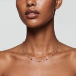 Model wearing Mia Tricolor Corundum Necklace layered elegantly at the neckline.