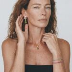 Model wearing the Peridot Necklace with a geometric diamond-shaped green pendant layered neatly against her collarbone for everyday polished styling