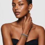 Model wearing handcrafted vineyard woven gold plated beaded bracelet styled as a statement piece on the wrist
