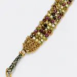 Close-up of an ONDA LENTA multicolor gemstone bracelet with faceted stones woven into an intricate 18K gold plated sterling silver design.