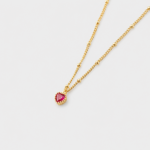 Perspective view showing textured gold bead accents and a faceted red heart pendant necklace in 18K gold plated sterling silver.