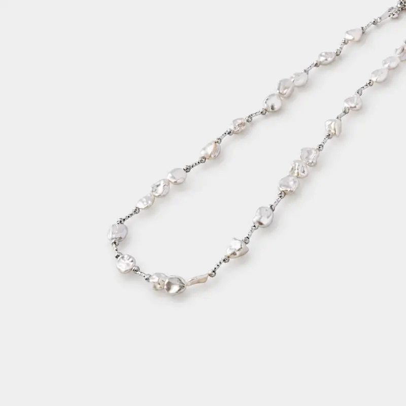 etailed close-up view of organic petal baroque pearls linked meticulously with clean 925 sterling silver chain links