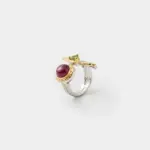 Profile detail view showing the textured bark-like silver band of the gemstone ring with a detailed gold plated bezel holding the ruby cabochon.