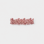 Side view showing the intricate openwork lace pattern woven with red garnet beads onto a flexible palladium plated metal frame.