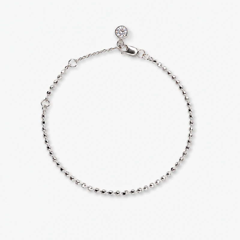 with Adjustable Chain and Stone Charm – ONDA LENTA Full view of an ONDA LENTA silver beaded bracelet featuring a delicate ball chain, adjustable extension, lobster clasp and clear stone charm.