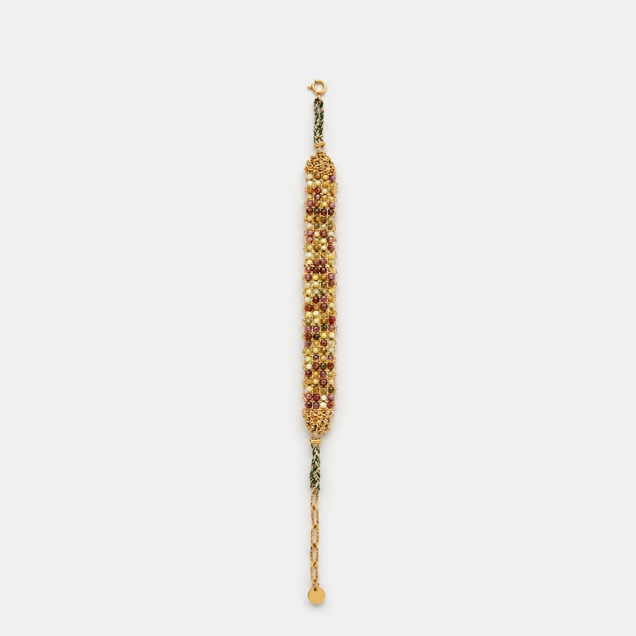 vineyard-woven-peridot-garnet-gold-bracelet Horizontal flat lay view of vineyard woven gold bracelet showcasing detailed gemstone rows of green peridot and red garnet beads