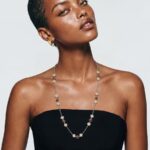 Model wearing Gin red ruby stud earrings and matching mixed-metal necklace on her ears and neck for an elegant evening look paired with a black strapless dress