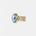 ONDA LENTA statement ring featuring an oval blue Mabe pearl centerpiece with a sculptural two-tone gold and silver textured band.