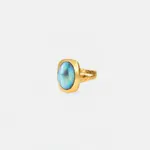 ONDA LENTA gold statement ring featuring an oval iridescent blue-green gemstone with a textured geometric split band.
