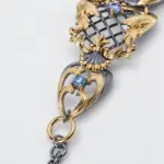 Close-up detail of an ONDA LENTA pearl cuff bracelet showing sculptural gold and silver metalwork, engraved textures, and decorative gemstone settings.